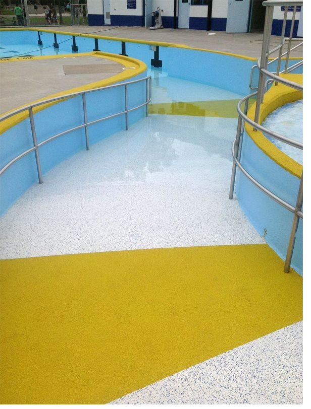 Blue poured rubber splash pad at a community pool