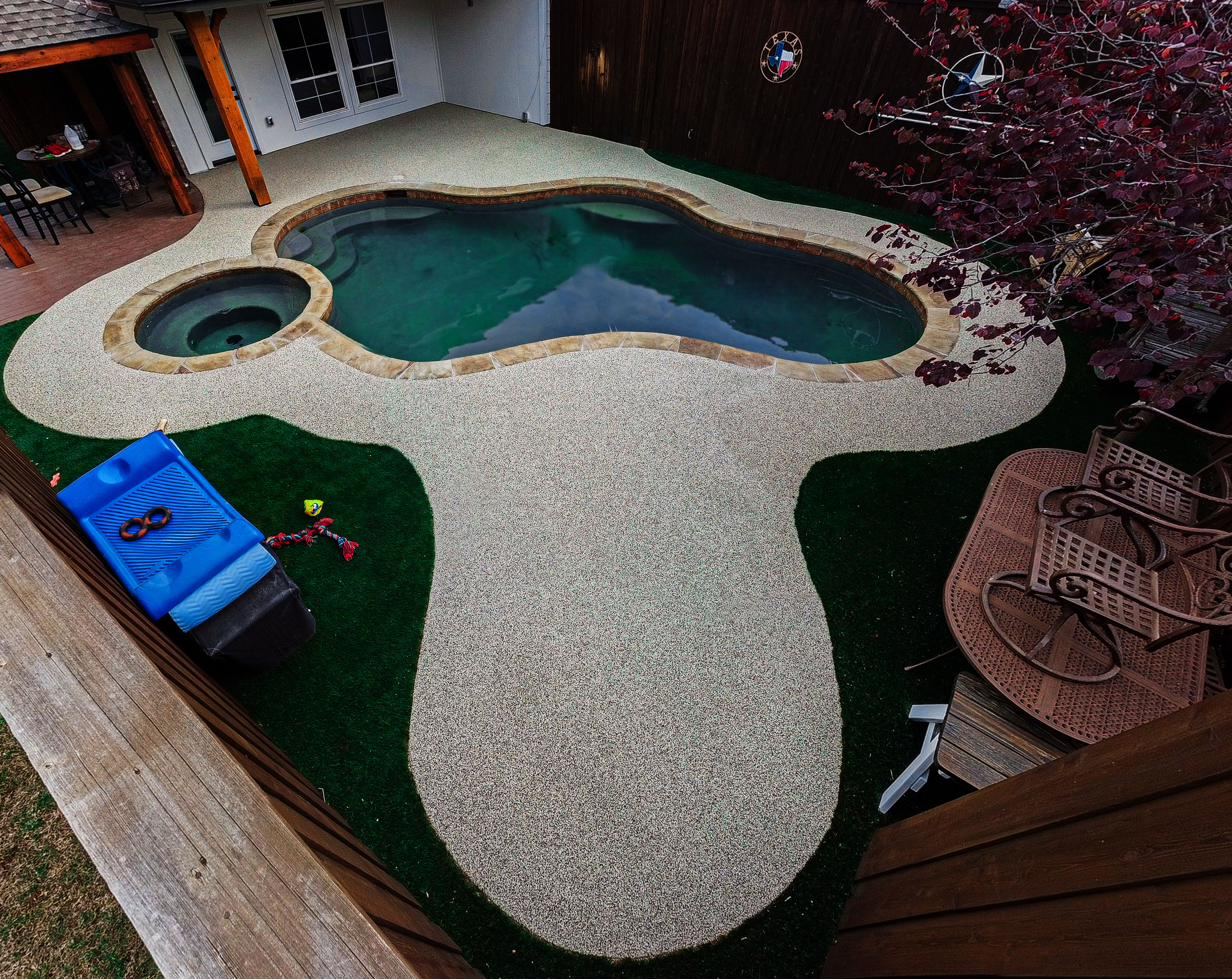 Tan poured rubber pool deck with a brown border around an octagonal pool